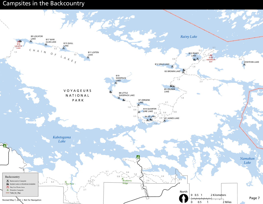 A map shows three large lakes surrounding a large peninsula of land. Dotted lines mark trails along the peninsula, which connect to a series of smaller lakes. 15 campsites are shown on the shores of the smaller lakes, indicated by tent symbols.