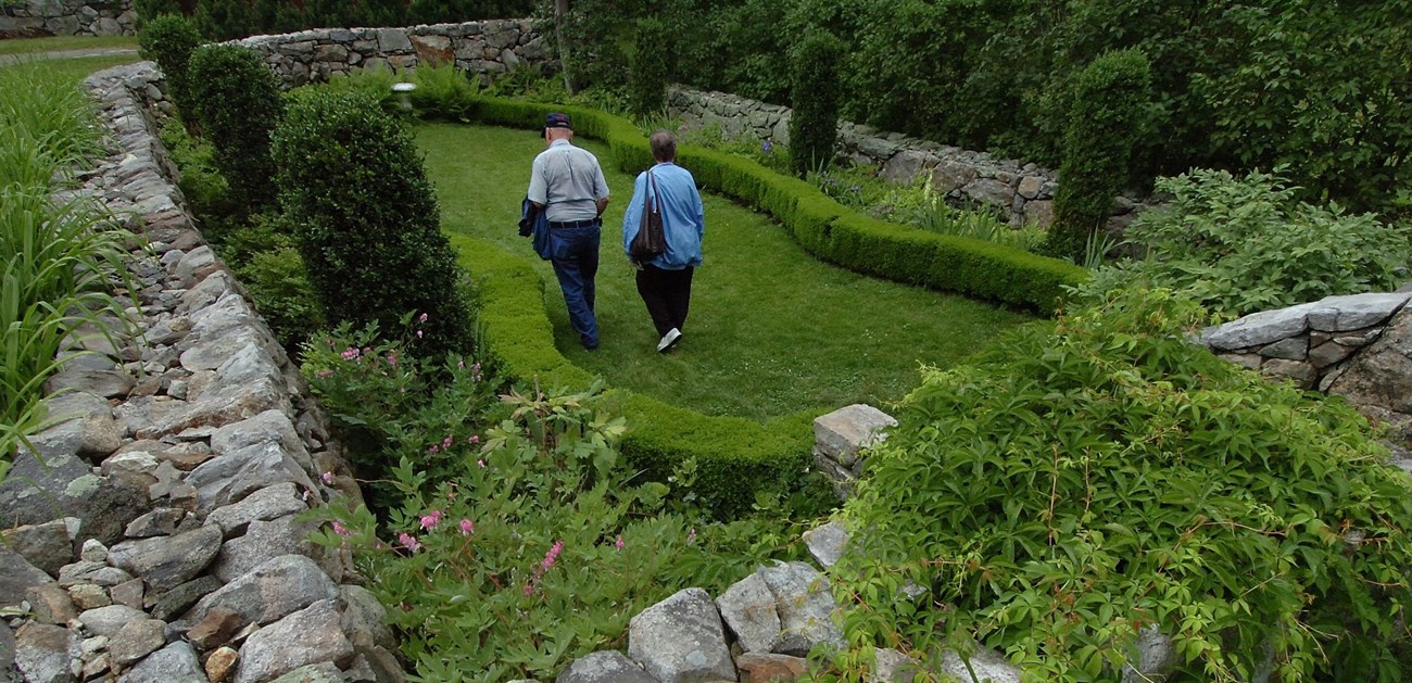 A man and women walking in a sunken garden.