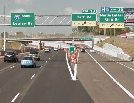 A green street sign above the highway