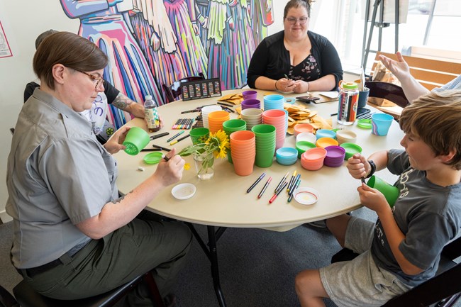 A group of people sitting at a table making crafts