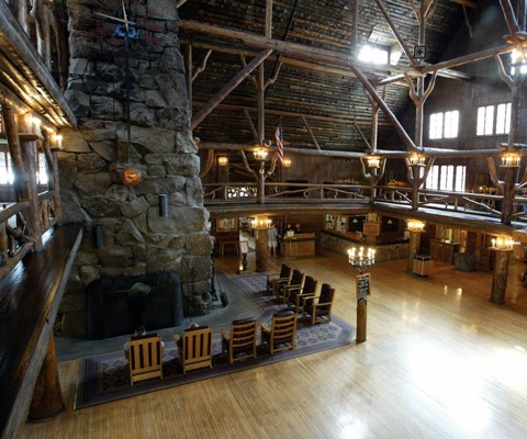 A tall stone fire place and seating area from a balcony