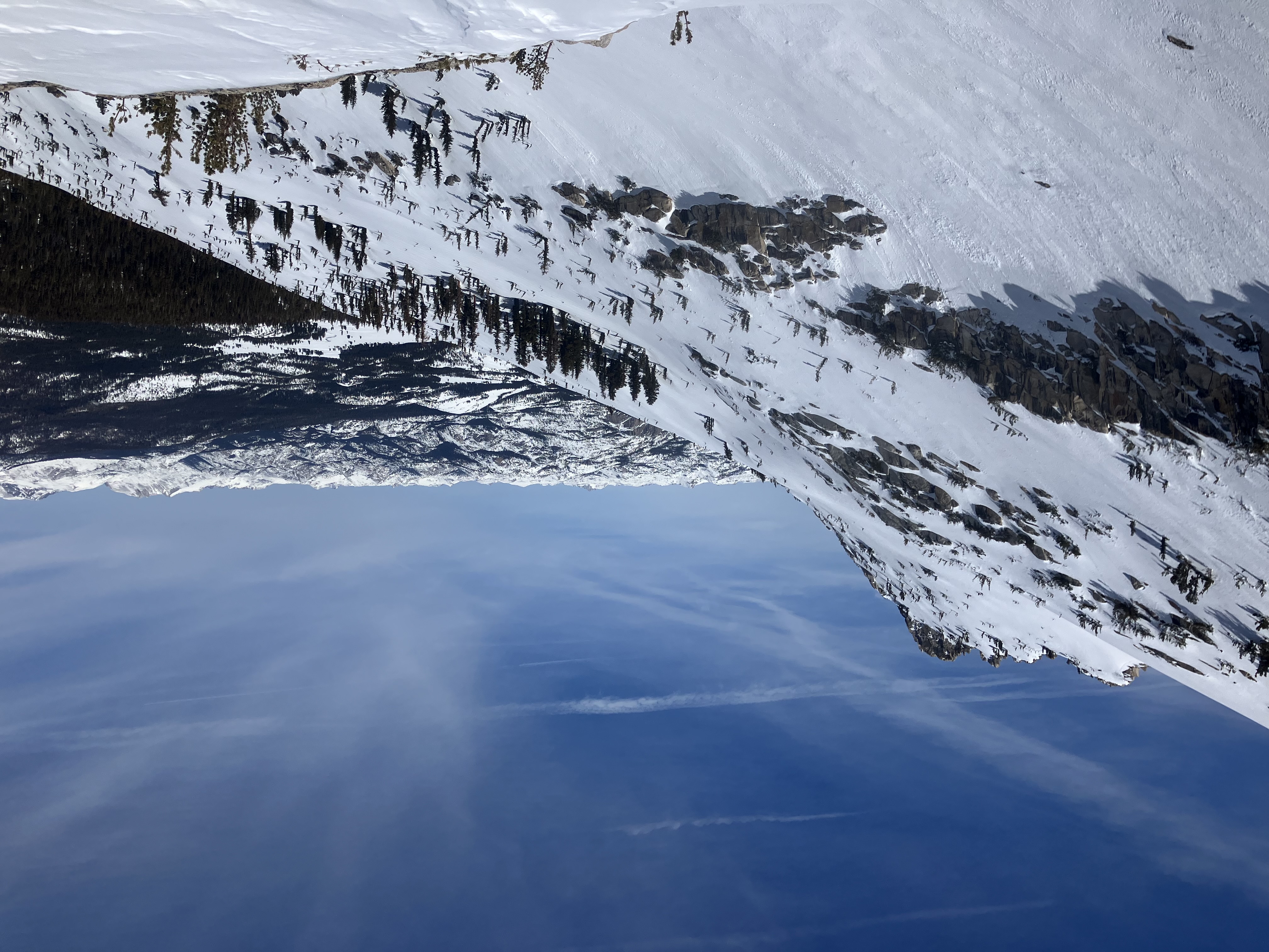 Tuolumne Meadows and surrounding high country, April 4th, 2025 Looking down from the side of a snowy ridge toward a snowy Tuolumne Meadows surrounded by forest and numerous snowy peaks beyond that
