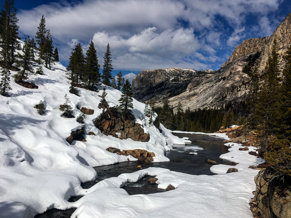 River surrounded by snow curves into a mountain landscape